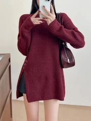 Close-up of a woman wearing a burgundy ribbed knit longline tunic with side slits and buttons, showing the detail of the buttons and the fabric texture.