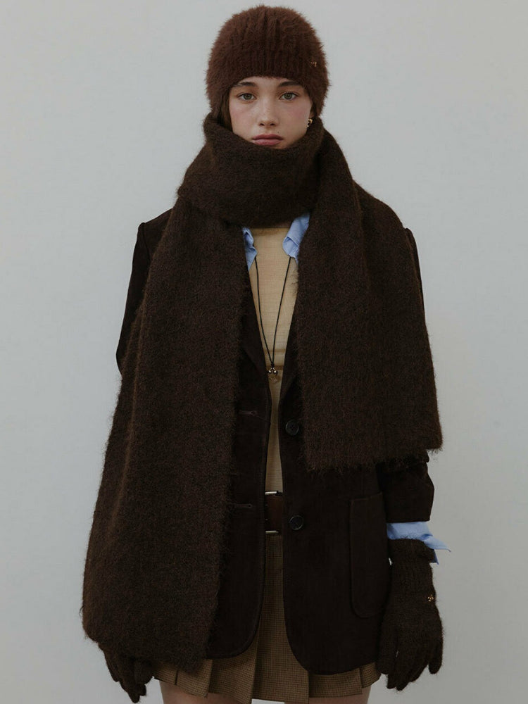 Model wearing a brown fuzzy hat, scarf, jacket, and gloves