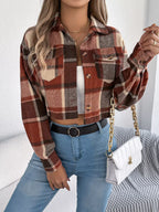 Model posing with a white quilted handbag while wearing a cropped plaid jacket, white tank top, and blue jeans.