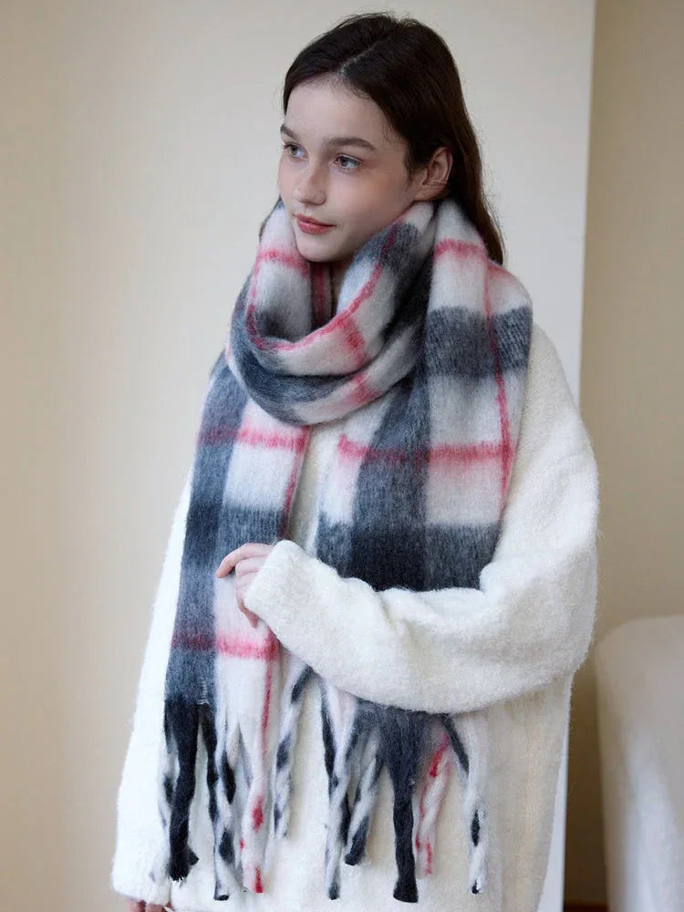 Woman wearing a cream-colored sweater and a plaid scarf, looking to the side.
