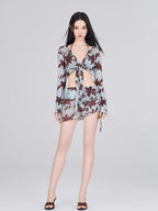 Full-length view of a woman in a light blue and brown floral print sheer mesh two-piece set.