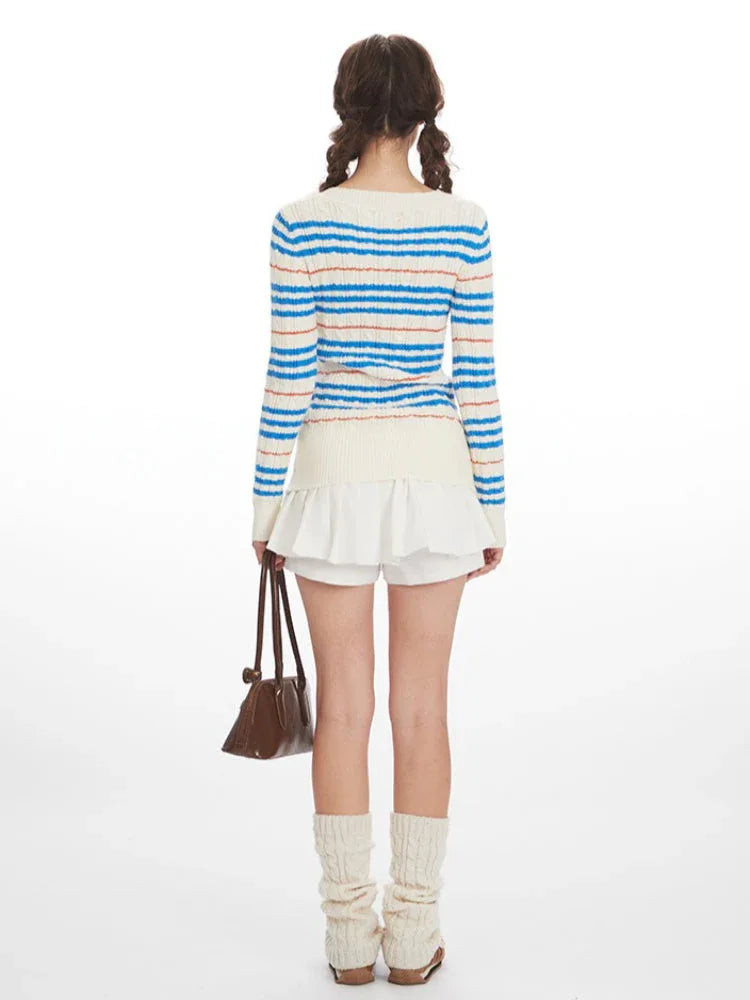 Back view of a woman wearing a striped v-neck sweater with a white ruffled skirt and beige leg warmers, holding a brown handbag. Secondary image