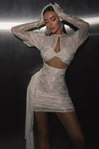Woman wearing a white textured mini dress with puffed sleeves and a cut-out detail