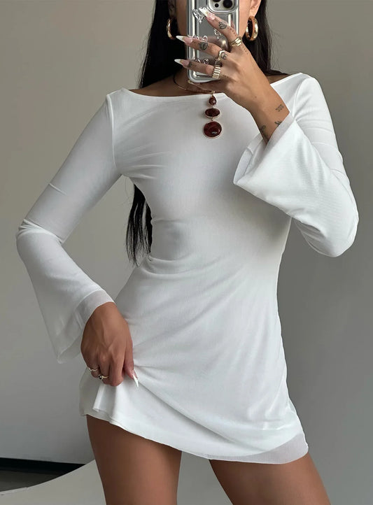 Close-up of the white long-sleeve mini dress, showing the fabric texture and sheer hemline.