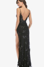 Woman wearing a black sequined formal gown with a high slit and deep V-neck, back view