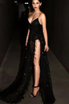 woman posing in a dark hallway wearing a black sequined gown