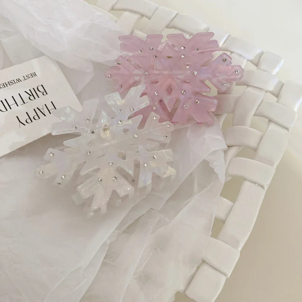 Pink and white iridescent snowflake hair clips in a white woven basket
