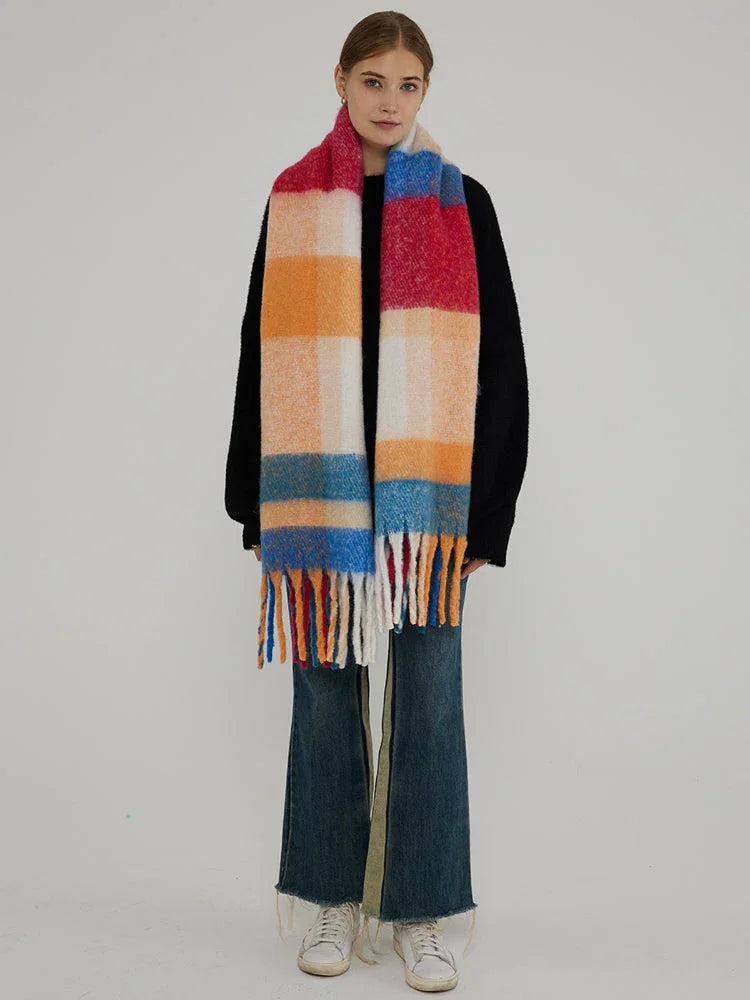 Full-body shot of a woman wearing a black sweater and a colorful plaid scarf