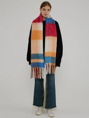 Full-body shot of a woman wearing a black sweater and a colorful plaid scarf