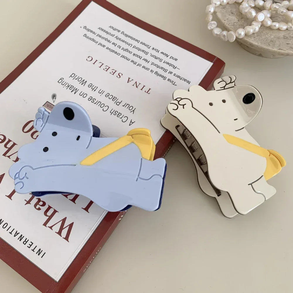 White and blue bear-shaped hair clips on top of books