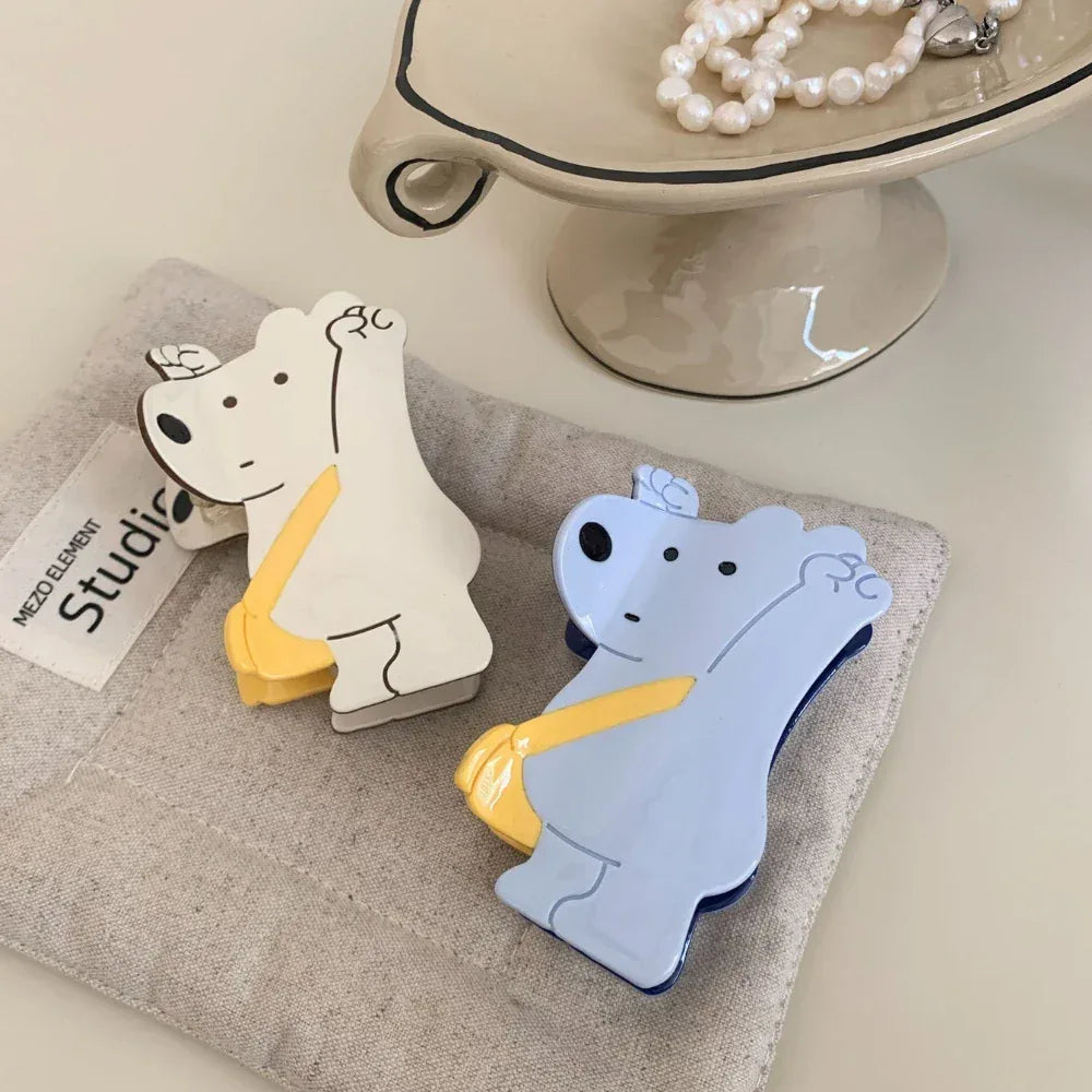 White and blue bear-shaped hair clips next to a fabric pouch