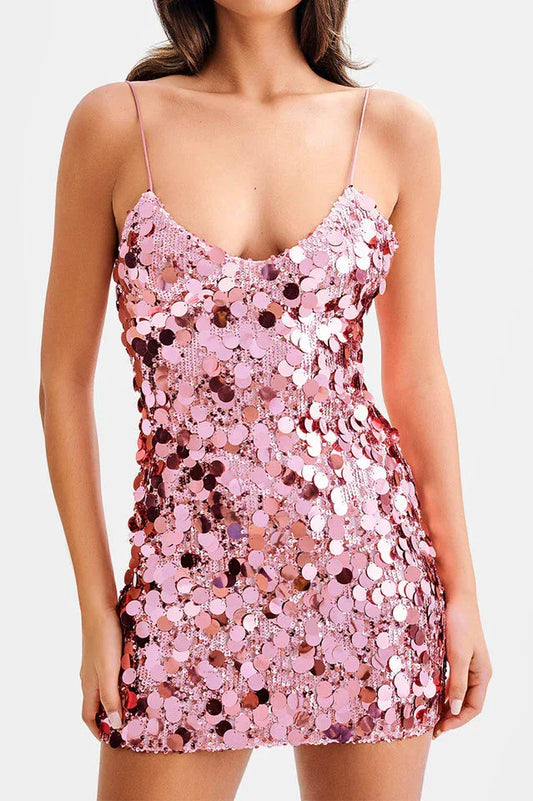 Woman wearing a pink sequined mini dress with spaghetti straps
