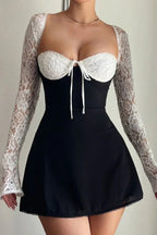 woman wearing a black and white lace mini dress, front view