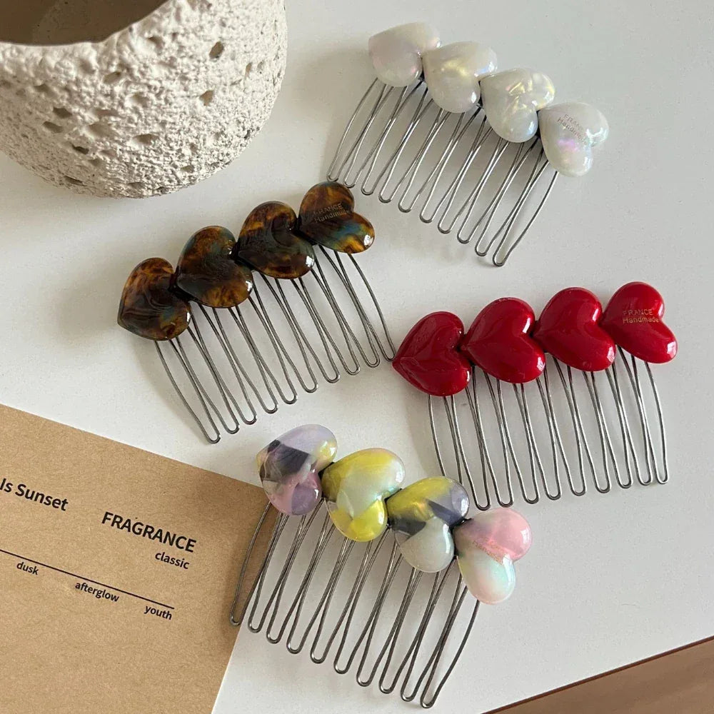Close-up of heart-shaped hair combs with different colored embellishments