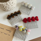 Close-up of heart-shaped hair combs with different colored embellishments