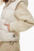 Close-up of the side pocket of a cream puffer vest worn by a woman