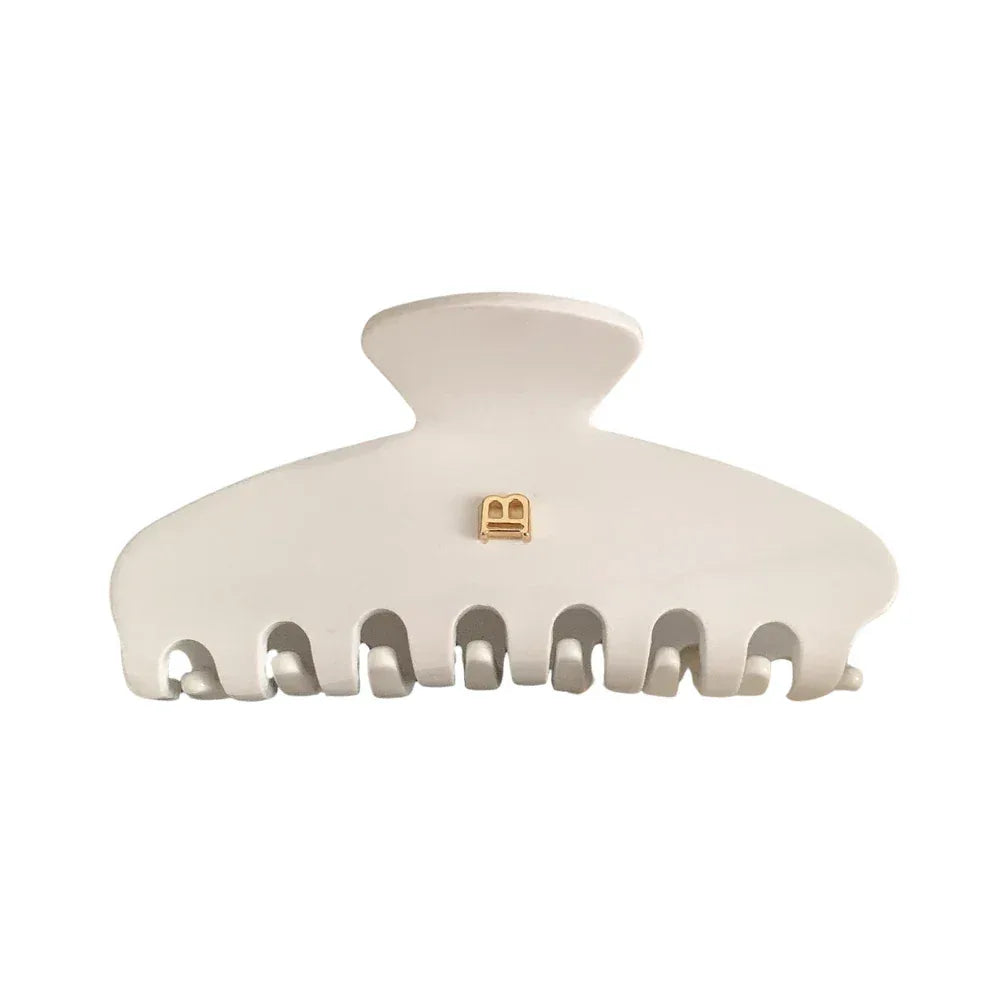 White matte claw clip with gold-tone 'B' logo