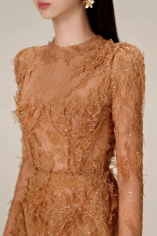 Close-up of the textured lace and embellishments on the bodice of the brown mini dress.