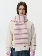 Woman wearing a pink and grey striped fuzzy scarf
