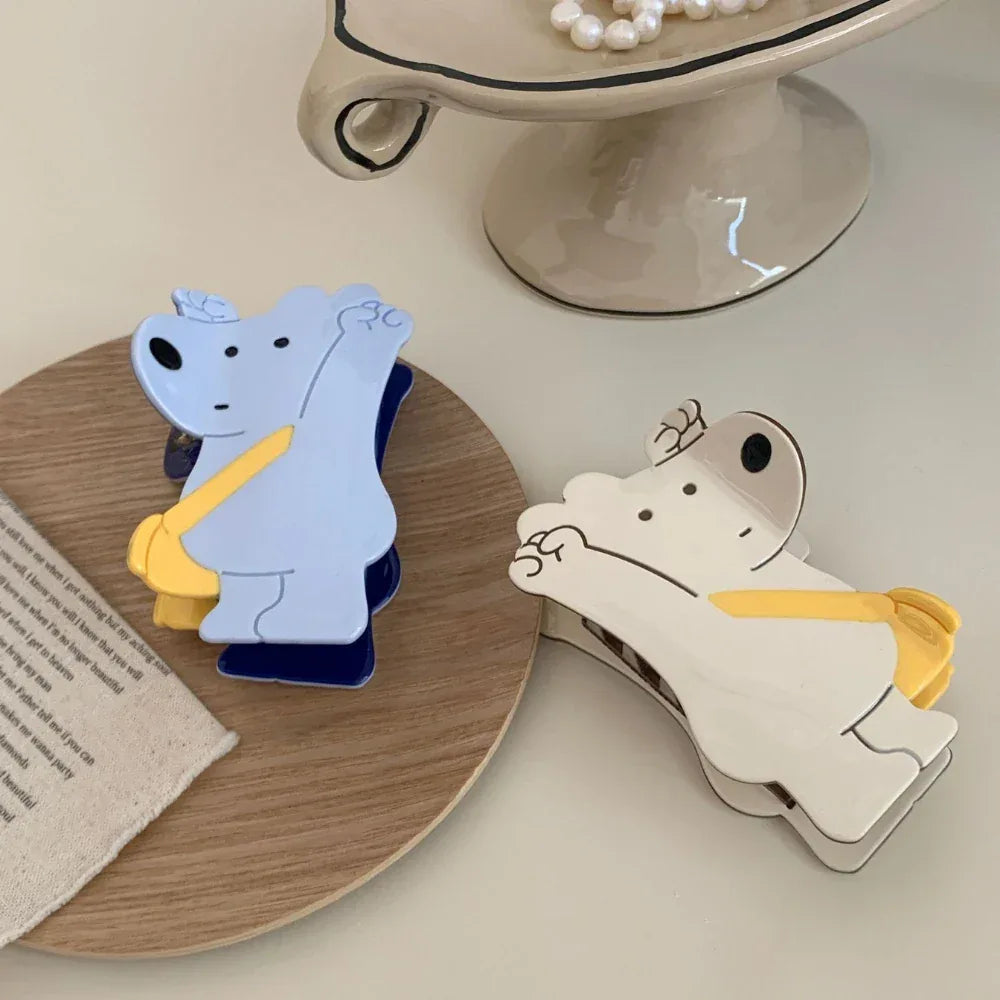 White and blue bear-shaped hair clips on a wooden coaster