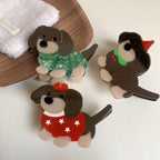 A top-down view of three charming acrylic dachshund dog brooches. They are arranged on a white surface, showcasing their individual festive designs.
