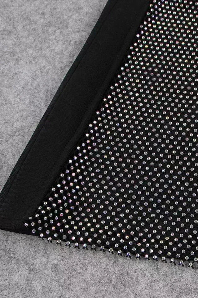 Close-up of the sheer mesh panel with rhinestone embellishments on the leg of the black jumpsuit.