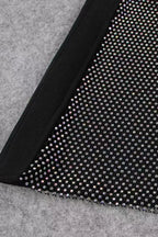 Close-up of the sheer mesh panel with rhinestone embellishments on the leg of the black jumpsuit.
