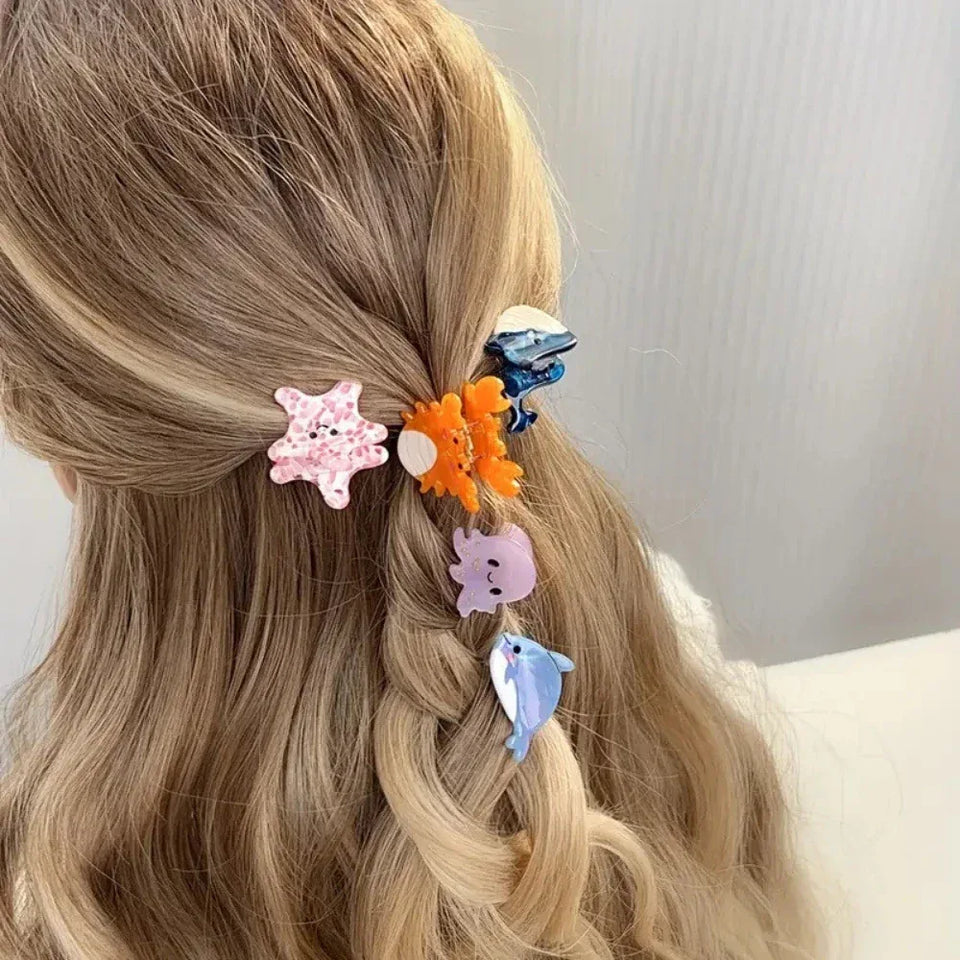 A woman's braided blonde hair adorned with several colorful ocean-themed hair clips. Secondary image