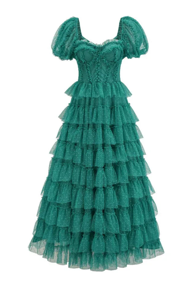 A full-length emerald green tiered tulle gown with puff sleeves and a sweetheart neckline, displayed on a mannequin.