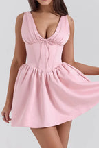 Pink sleeveless V-neck dress with a fitted bodice and flared skirt, side view showing movement