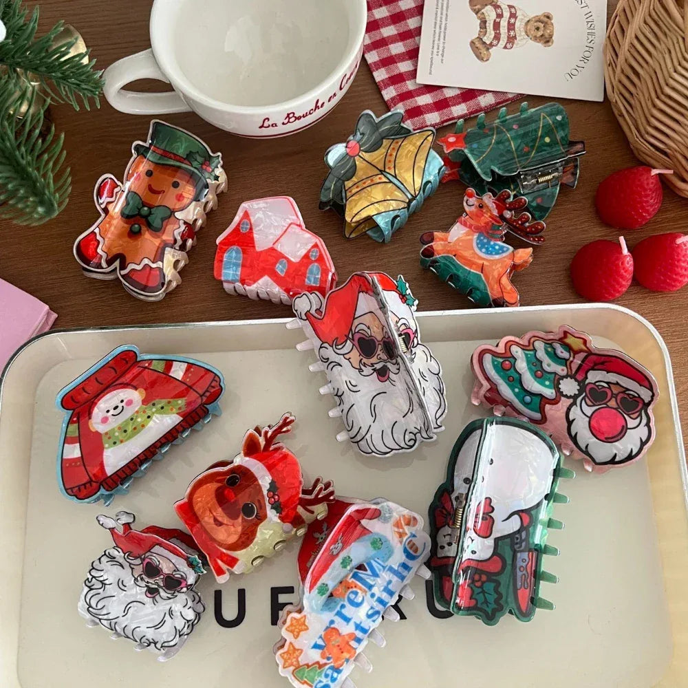 Assortment of holiday-themed hair claw clips displayed on a white tray and a wooden table, featuring gingerbread men, Santas, and snowmen.