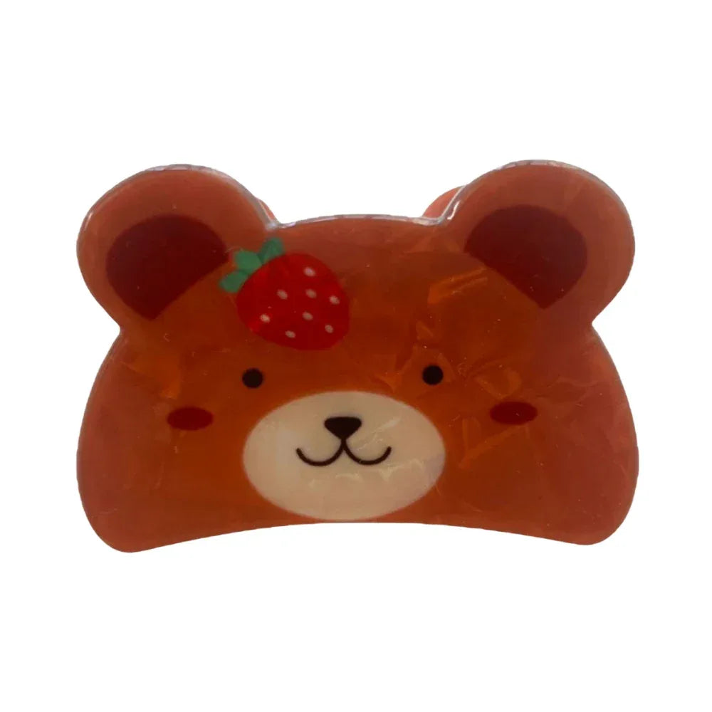 A close-up image of a glossy brown bear-shaped hair clip with a strawberry on its head.