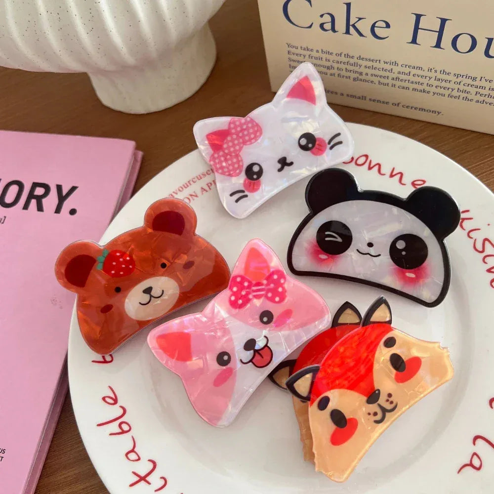 A top-down view of several animal-themed hair clips placed on a white plate with text in the background.