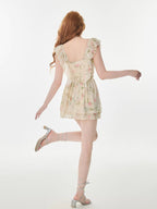 Rear view of a woman in a floral print mini dress, showcasing the back and movement.