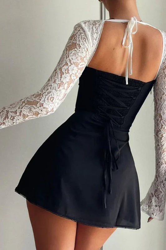 woman wearing a black and white lace mini dress, back view