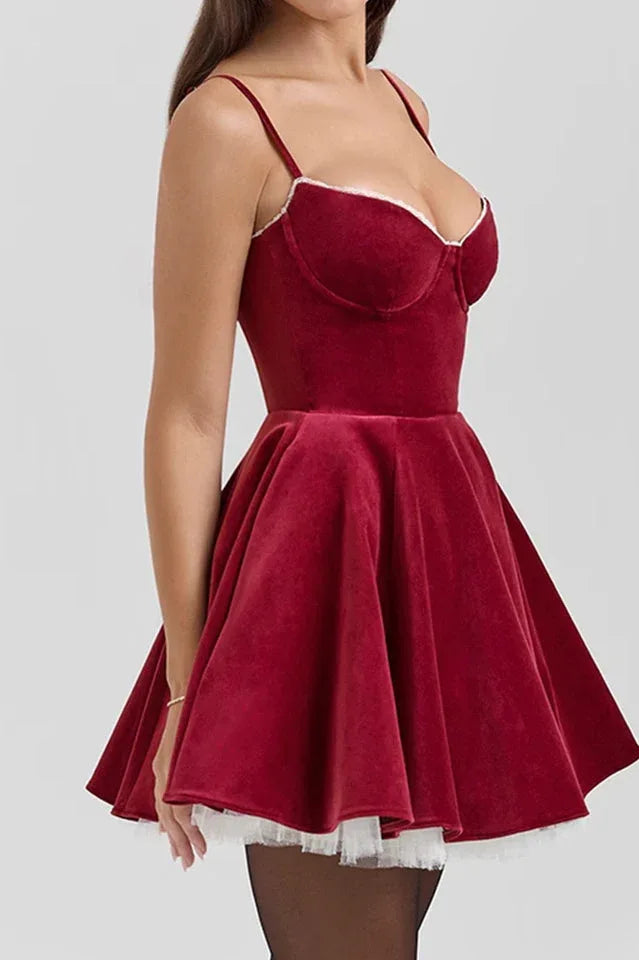 Side view of a woman in a red velvet A-line dress with a full skirt. Secondary image