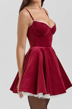Side view of a woman in a red velvet A-line dress with a full skirt.