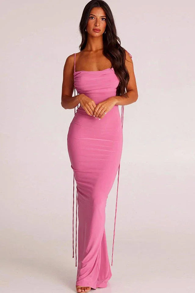 Woman wearing a long pink ruched dress with spaghetti straps and an open back Main image