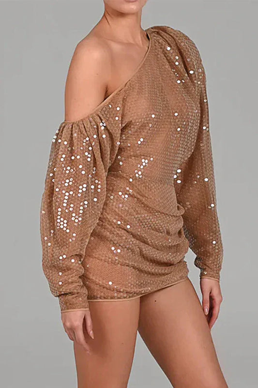 Side view of a woman in a shimmering sequined one-shoulder dress.