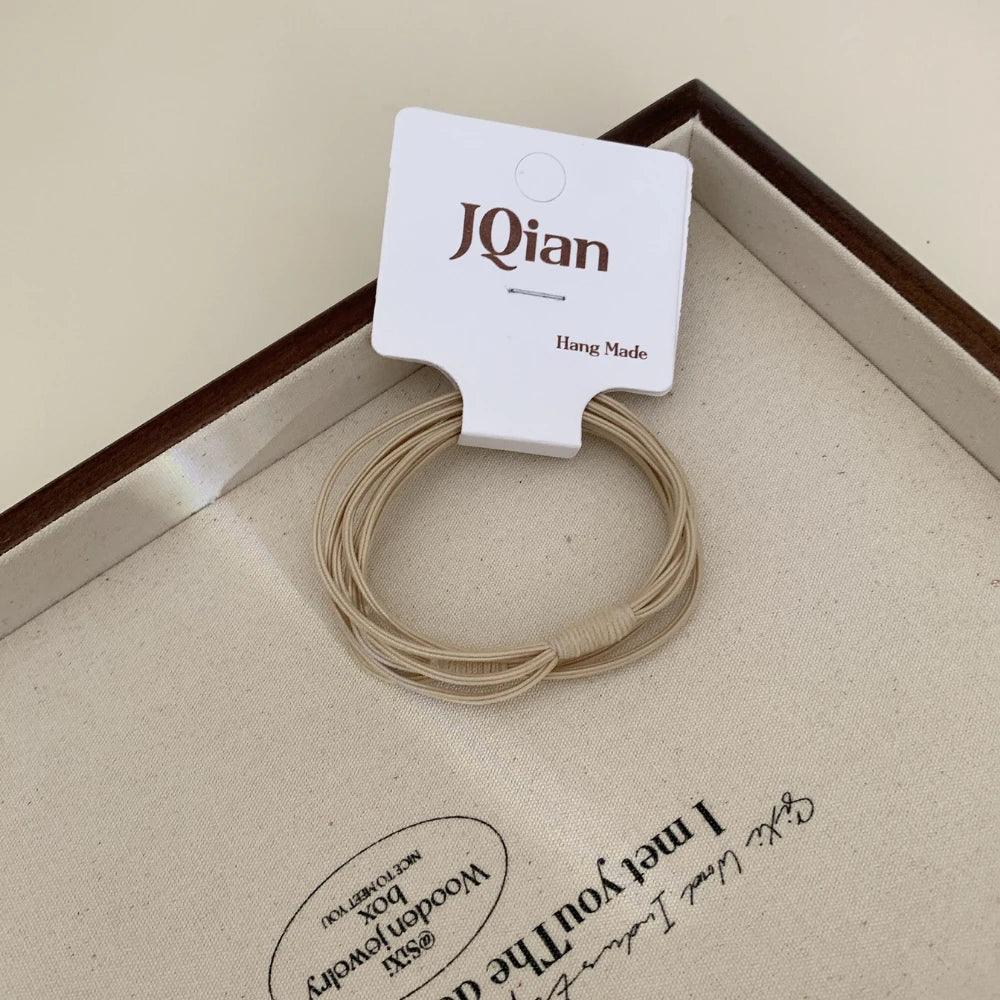 A single pack of JQian beige elastic hair ties, showcasing the product and packaging.