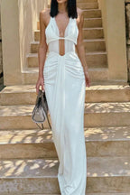 Woman in a white halter neck maxi dress with a plunging neckline and ruched detailing, from the front.