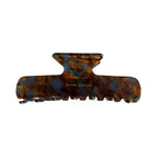 A tortoiseshell patterned hair claw clip with blue and brown swirls, against a white background.