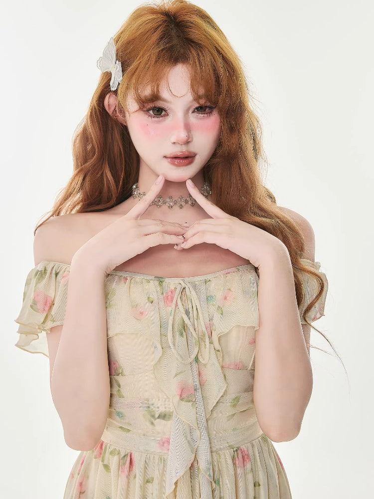 Close-up of a woman wearing a floral print dress with off-the-shoulder flutter sleeves.