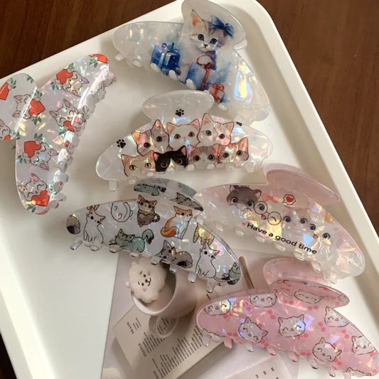 A collection of various cat-themed claw clips arranged on a white tray.