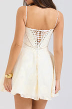 Back view of a woman in a cream-colored dress with lace-up corset detailing.