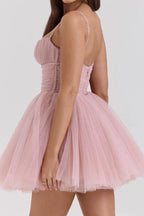 back view of woman in pink mini dress with ruched bodice and tulle skirt