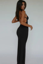 Back view of a woman in a black maxi dress with an open back.