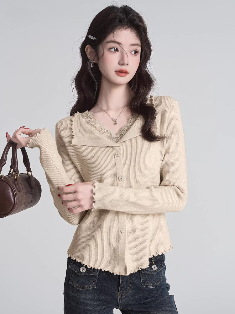Woman wearing a beige ribbed knit cardigan with lace trim and a V-neck, holding a brown handbag.