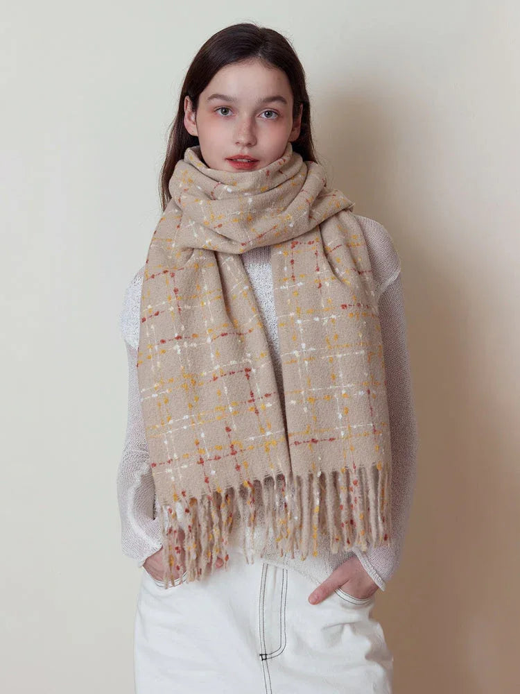 Woman wearing a beige plaid scarf with red and yellow accents