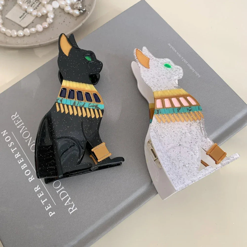 Black and white glitter Egyptian cat hair clips on a book